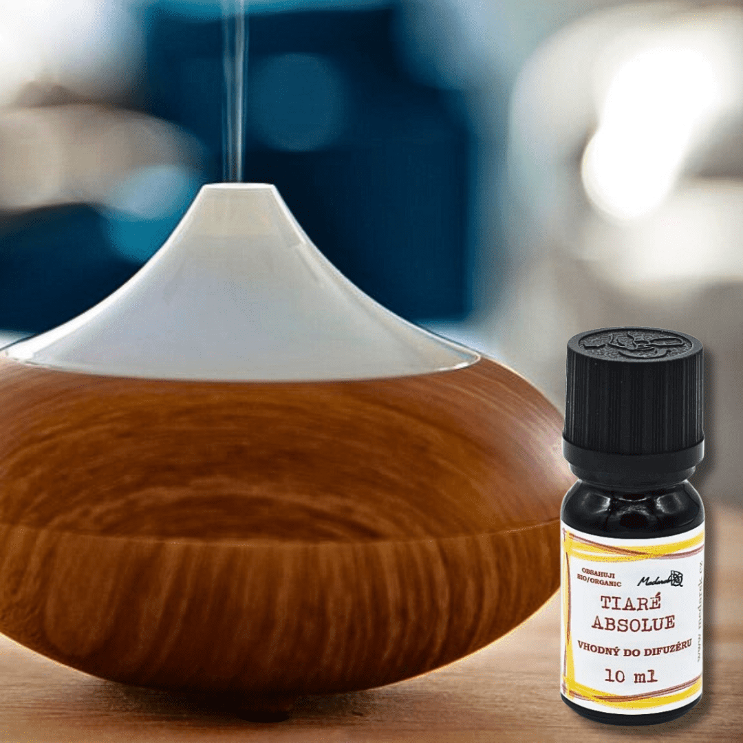 Ultrasonic diffuser releasing mist with a 10 ml bottle of Medarek Tiaré Absolute oil in the foreground.